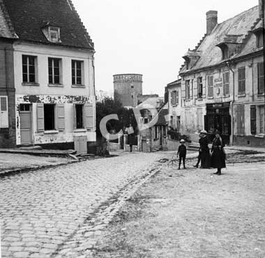 Une rue et au fond le donjon du château de Coucy