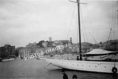 Un yacht dans le port de Cannes et les hauteurs de la ville en arrière-plan
