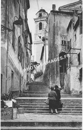 Ancienne carte postale d'une rue et l'église de Villefranche-sur-Mer en 1930