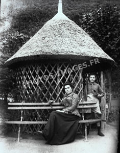 Photo d'une mère et son fils devant la paillote au toit de chaume du jardin