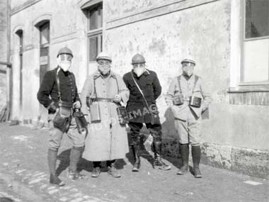 photo de 4 militaires qui  posent équipés de leur masque à gaz pendant la guerre de 14-18