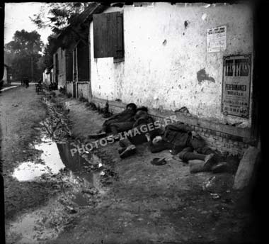 Photo de 4 soldats anglais au pied d'une maison endormis pendant la guerre de 14-18