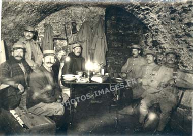 Photo de 7 militaires posant à la chandelle pour le photographe dans une cave